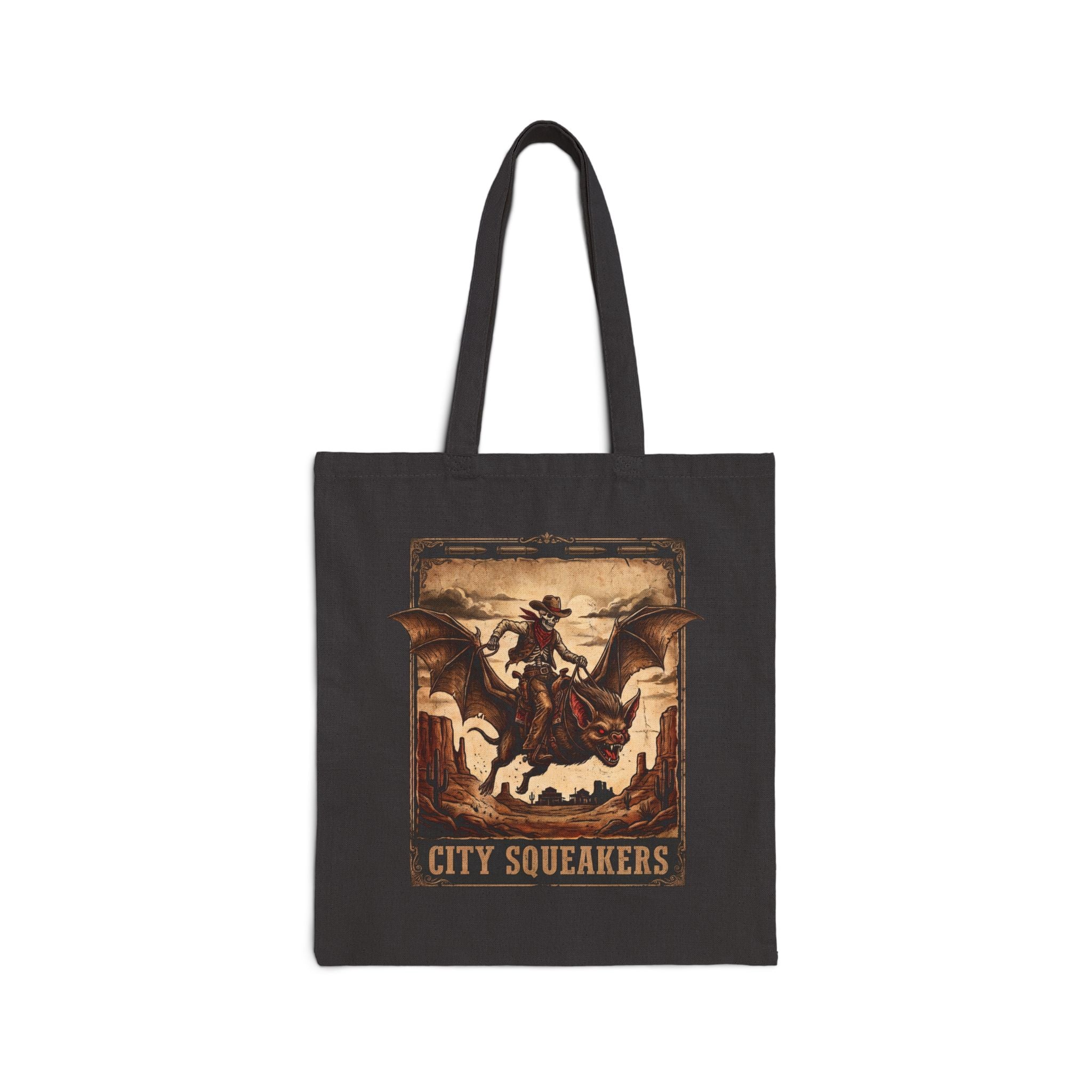 Front view of black Tote Bag City Squeakers tote bag featuring vintage sepia skeleton cowboy riding a winged bat creature over a desert canyon — gothic western graphic shoulder bag