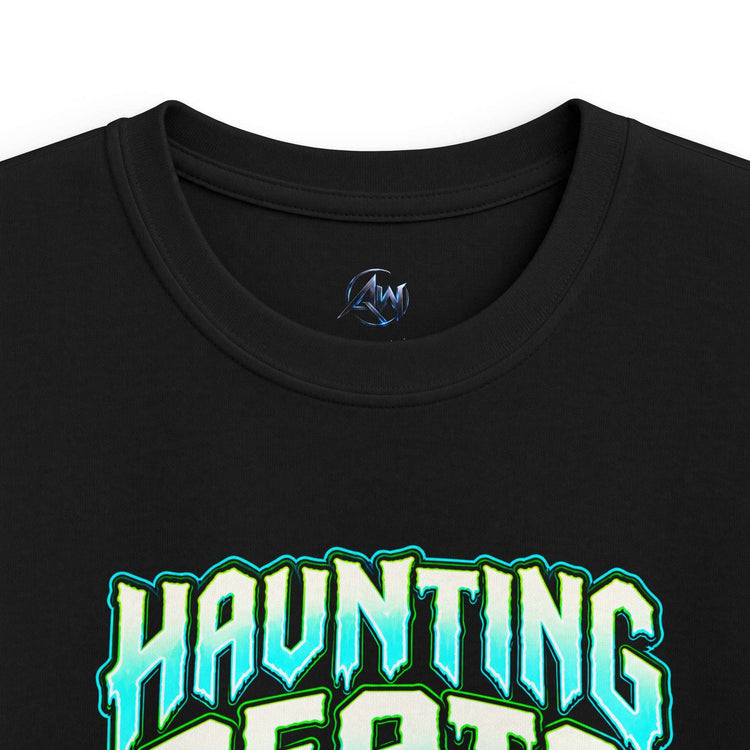 Close-up of a black crewneck t-shirt featuring a stylized graphic that reads 'HAUNTING BEATS' in a light blue and green gradient with a dark outline. A small blue circular logo is printed inside the collar.