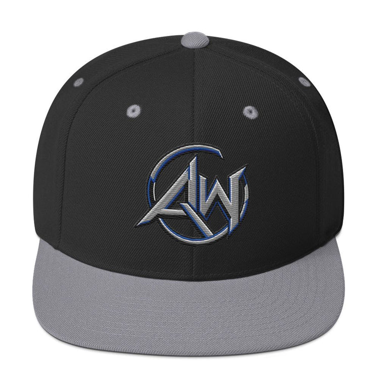 A structured snapback cap with a black crown, gray flat brim, and a metallic silver and blue embroidered 'A.W' logo on the front.