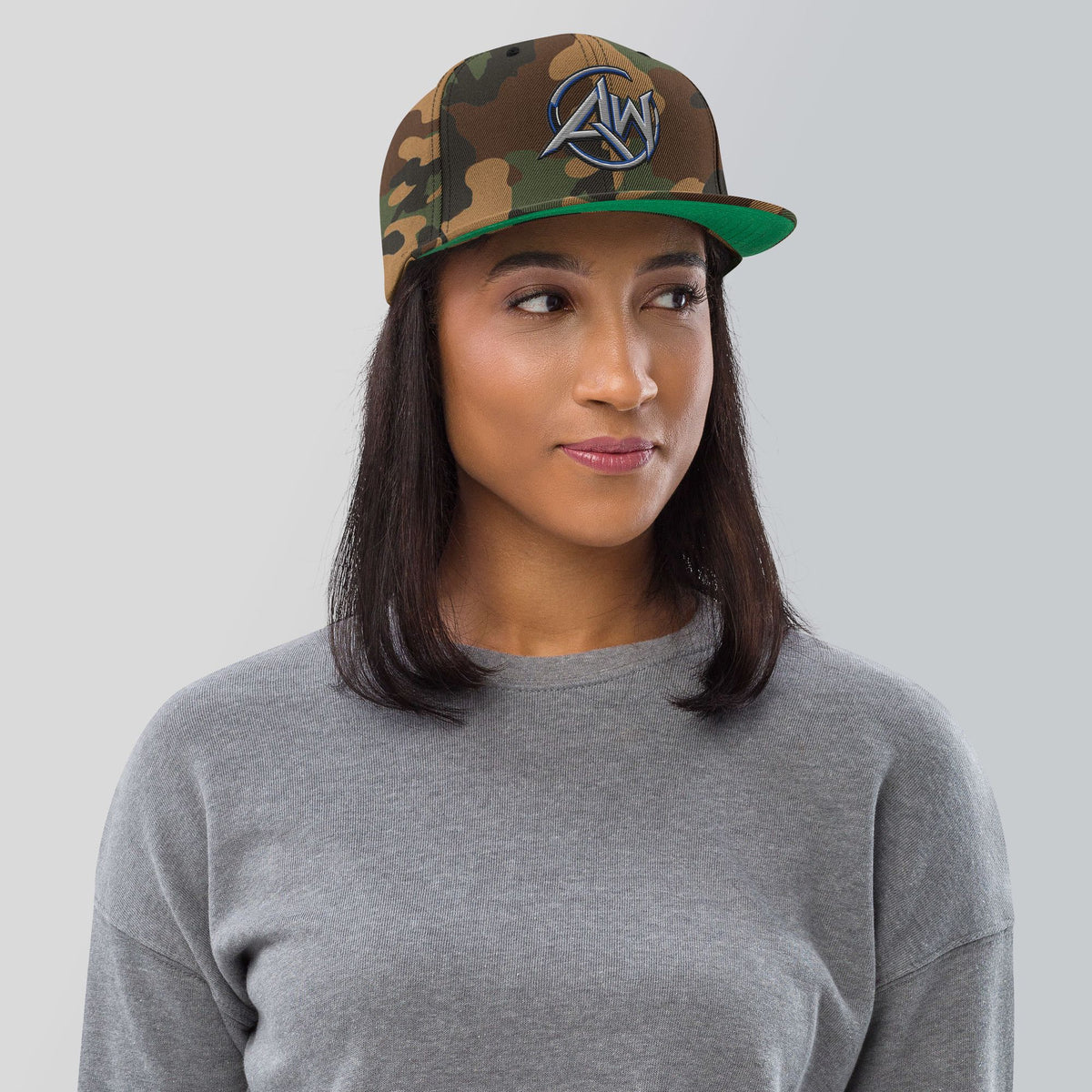 woman wearing a camouflage cap with an AW logo on a plain background