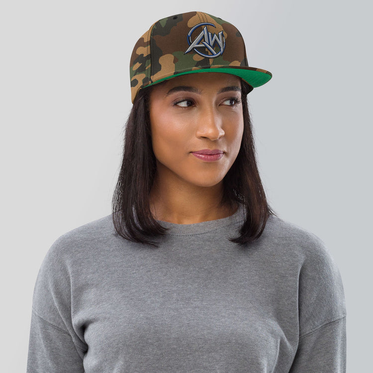 woman wearing a camouflage cap with an AW logo on a plain background