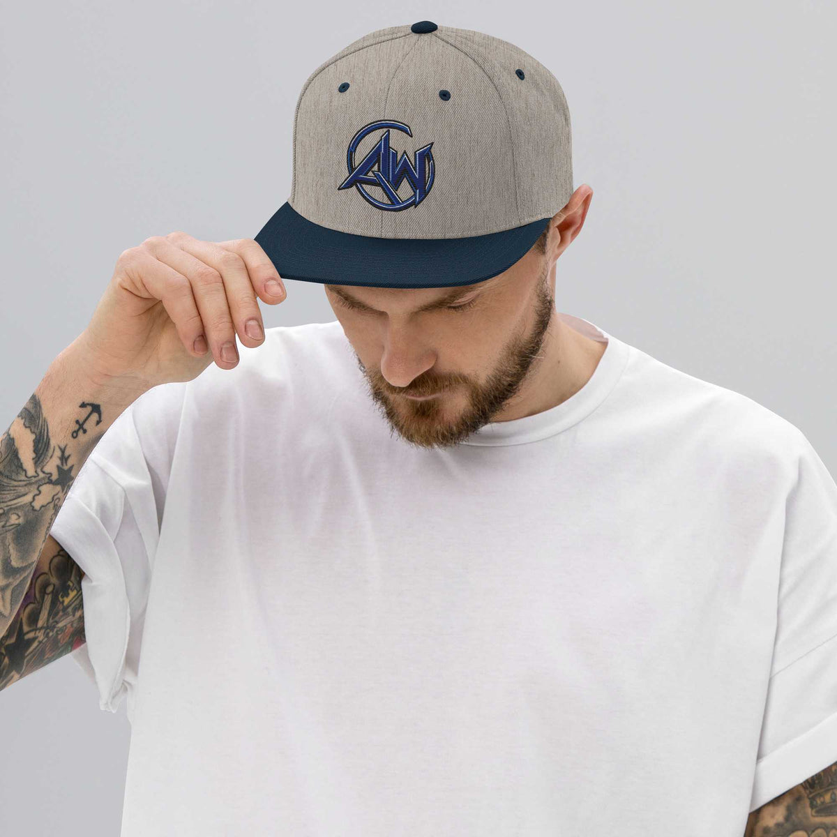 Man wearing a cap with AW logo on a plain background