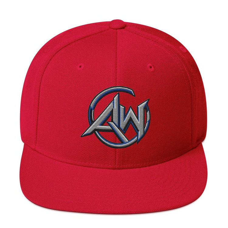 A red structured flat-brim cap featuring a metallic silver and blue embroidered AW circular logo on the front, set against a plain white background.