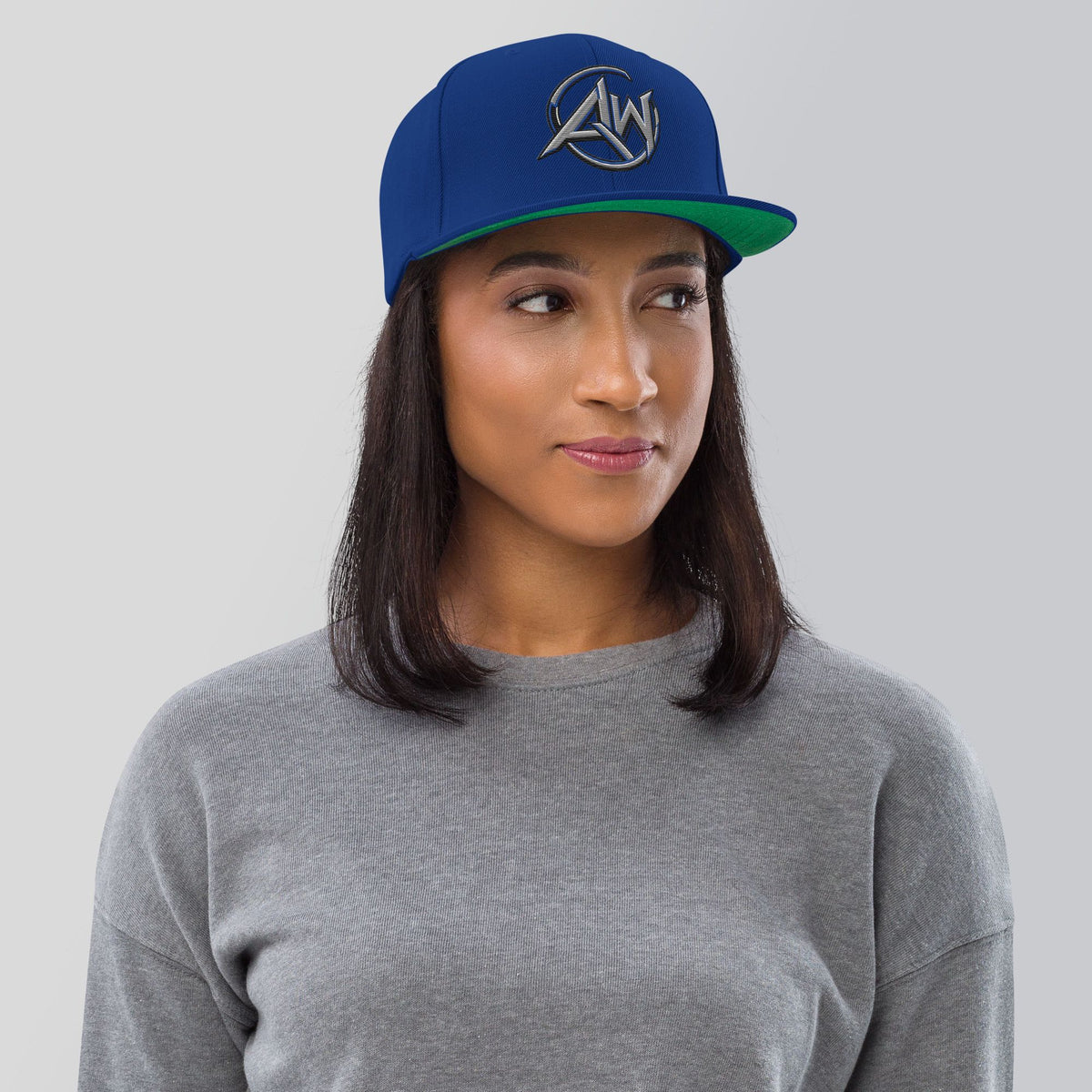 woman  wearing a blue cap with AW' text on a gray background