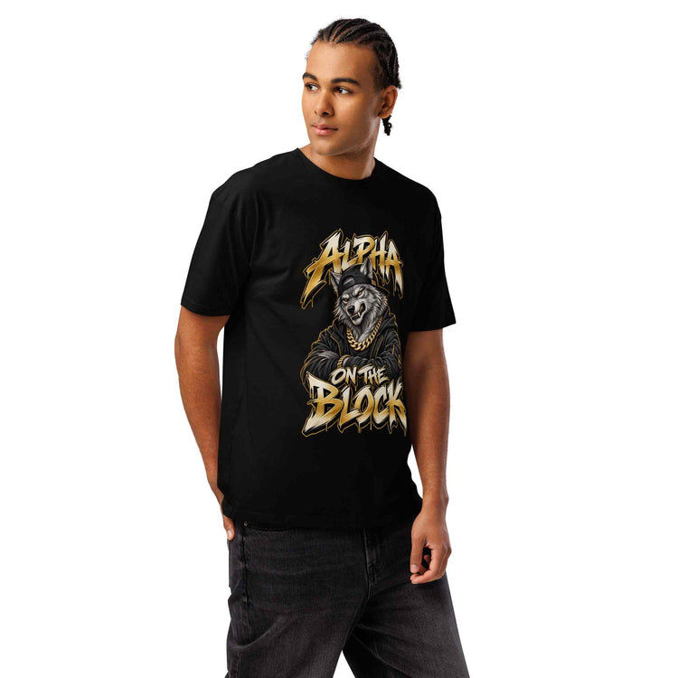 A man wearing a black short-sleeve graphic t-shirt with a gold and white 'Alpha on the Block' wolf design, paired with dark gray jeans, against a plain white background.