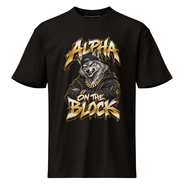 A black short-sleeve crewneck t-shirt featuring a graphic print of a wolf wearing a gold chain and cap, with the text 'ALPHA ON THE BLOCK' in a stylized gold and white font.
