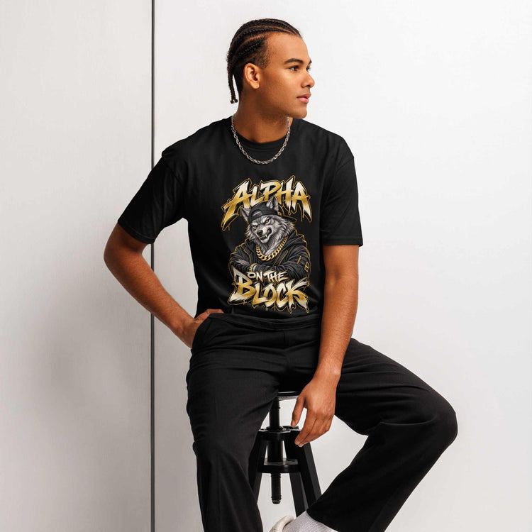 Man wearing a black t-shirt with a graphic wolf design, man sitting on a stool against a light gray background