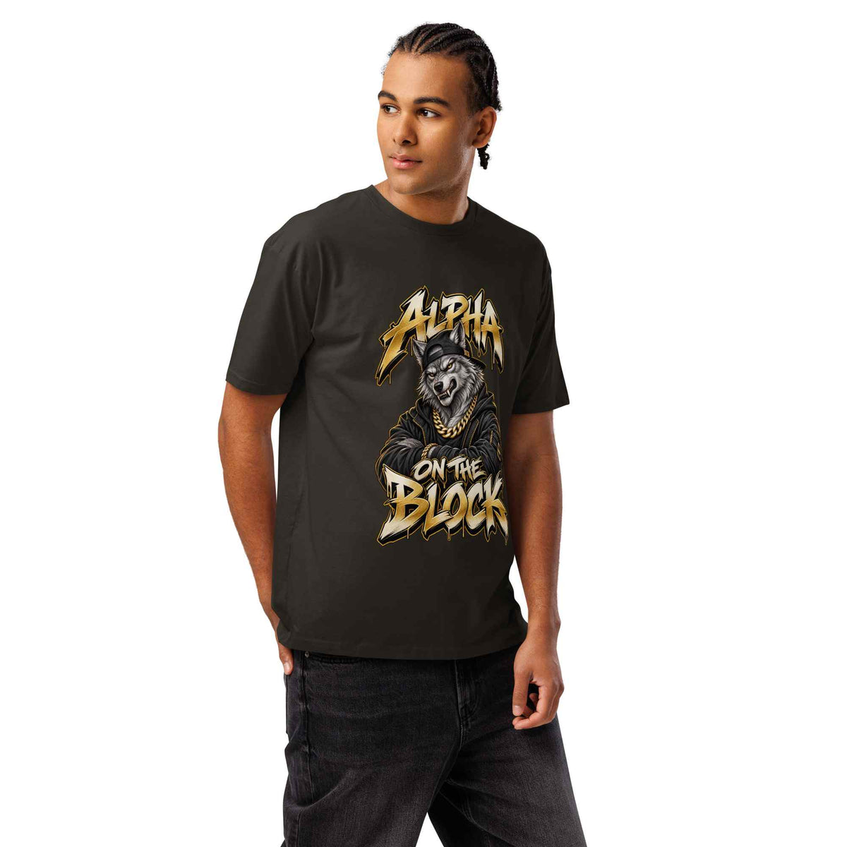 A man wearing a dark charcoal gray t-shirt with a graphic print of a wolf and the text 'ALPHA ON THE BLOCK' in gold and white, paired with dark jeans against a plain white background.