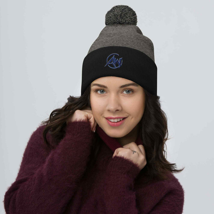 Woman wearing a two-toned beanie with a brand  AW logo on a plain background