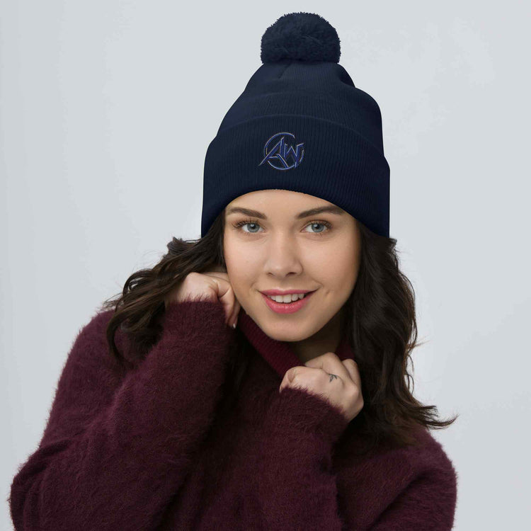 Woman wearing a navy blue beanie with an AW logo on a light gray background
