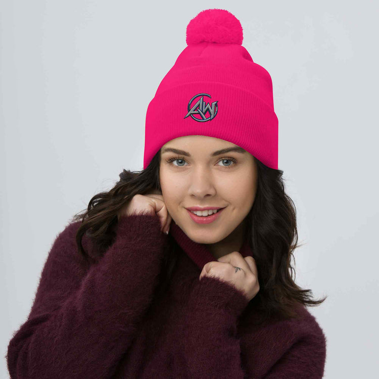 Woman wearing a pink beanie with a logo on a gray background