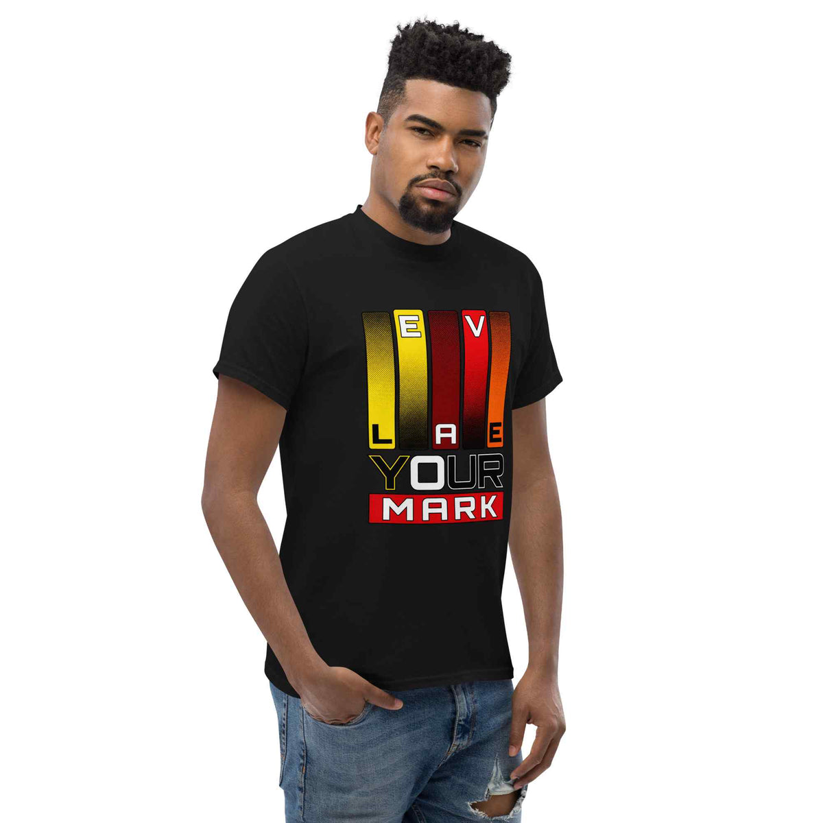A man wearing a black short-sleeve t-shirt with a colorful graphic that reads 'LOVE YOUR MARK' in yellow, red, and white vertical bars, paired with blue jeans, set against a plain white background.
