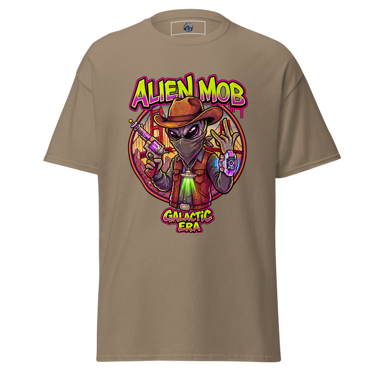 A savana brown short-sleeve t-shirt with a colorful graphic print of an alien wearing a cowboy hat and vest, holding a gun, with the text 'ALIEN MOB' and 'GALACTIC ERA'.