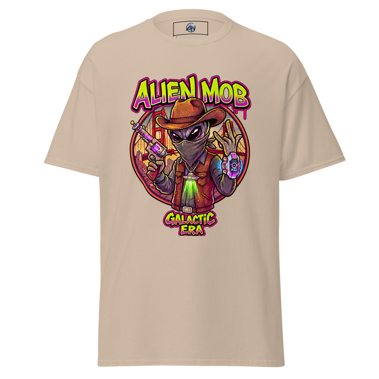 A Sand short-sleeve t-shirt with a colorful graphic print of an alien wearing a cowboy hat and vest, holding a gun, with the text 'ALIEN MOB' and 'GALACTIC ERA' on a white background.