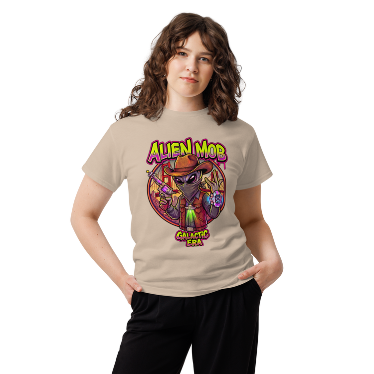 A woman modeling a sand graphic t-shirt with a colorful 'Alien Mob Galactic Era' design on the front, paired with black pants, against a plain white background.