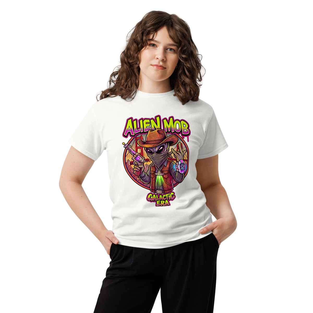 A woman modeling a white short-sleeve graphic t-shirt featuring a colorful cartoon alien design with the text 'ALIEN MOB' and 'GALACTIC ERA'.