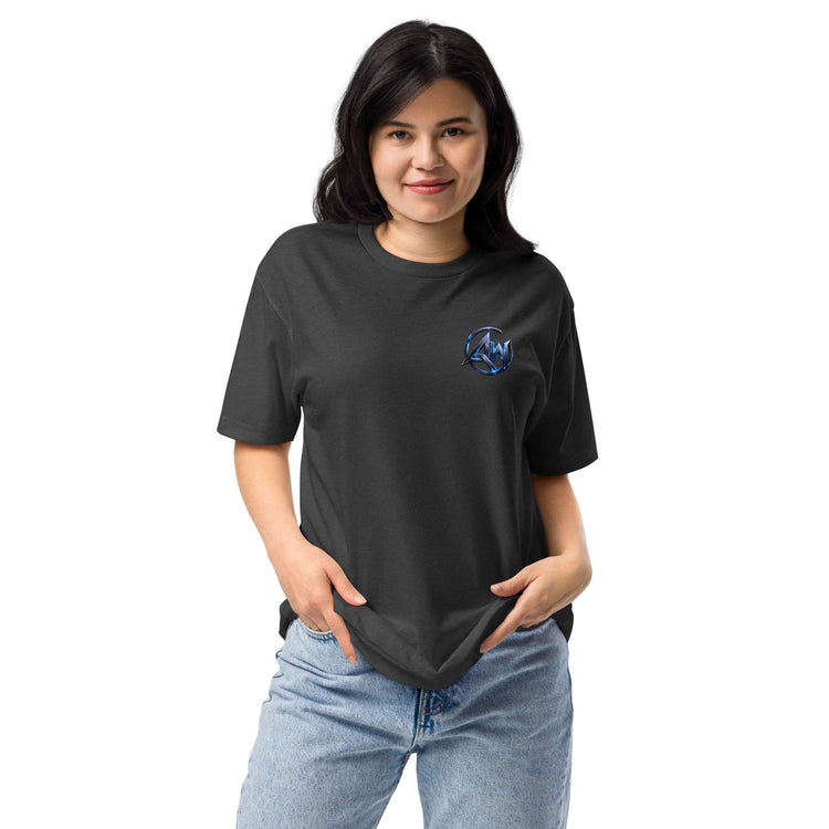 A woman modeling a dark charcoal gray t-shirt with a small blue circular graphic AW logo on the left chest, paired with light blue jeans, against a plain white background.