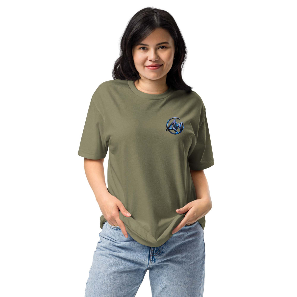 A woman modeling an olive green crewneck t-shirt with a small blue and white circular graphic AW logo on the left chest, paired with light blue jeans, against a plain white background.