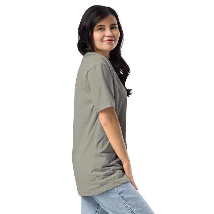 A woman wearing a taupe gray short-sleeve t-shirt short sleeve, paired with light blue jeans, shown from a side-back profile against a solid white background.