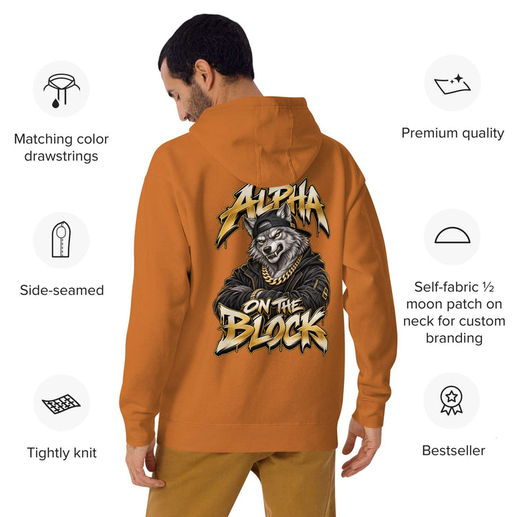 A man shown from the back wearing an orange hoodie with a large graphic wolf  print on the back reading 'Alpha on the Block' featuring a wolf wearing a gold chain. The image includes feature callouts icons around the model highlighting product details.