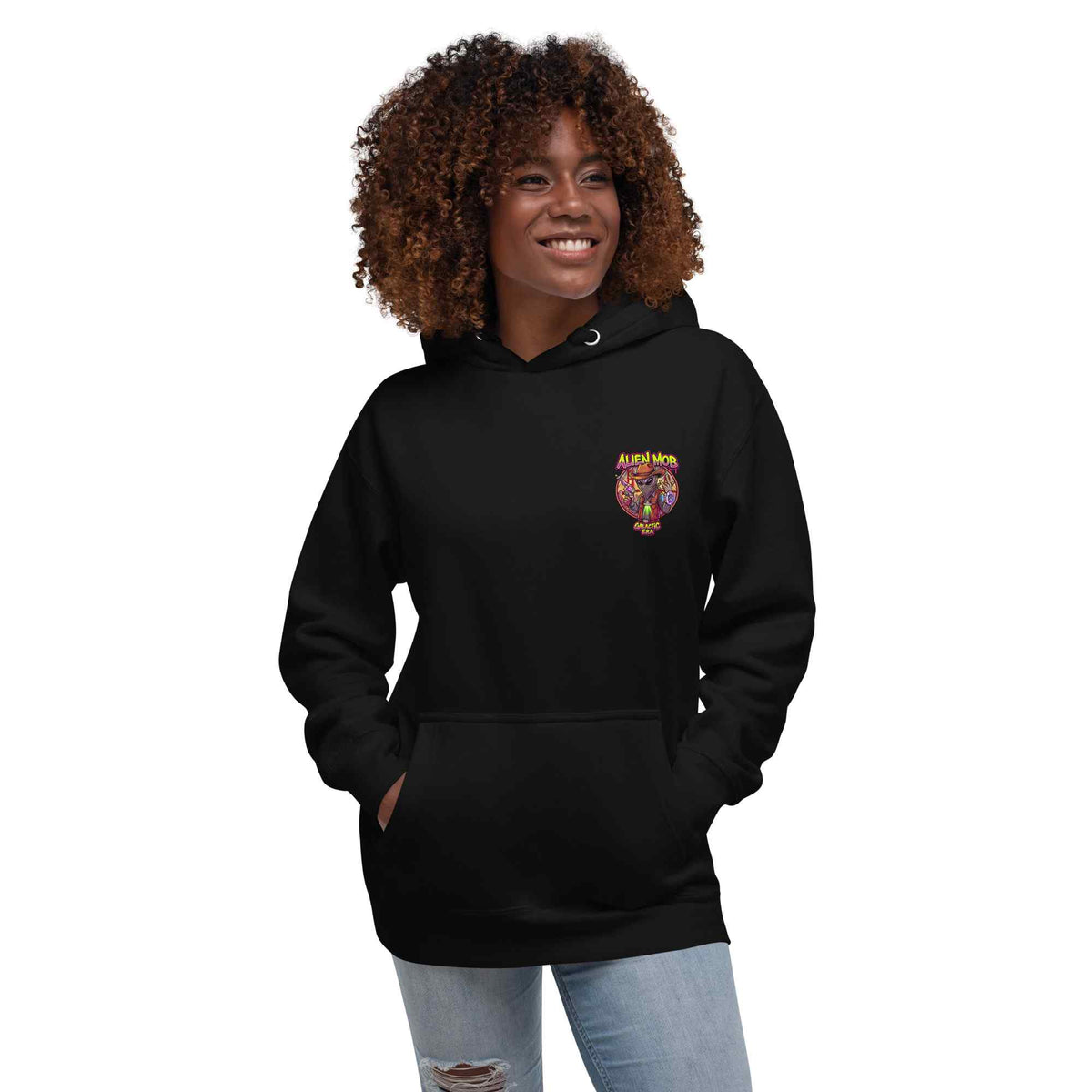 woman wearing a black hoodie with alien mob cowboy outlaw logo on the left side chest paired with blue jeans on a white background front view