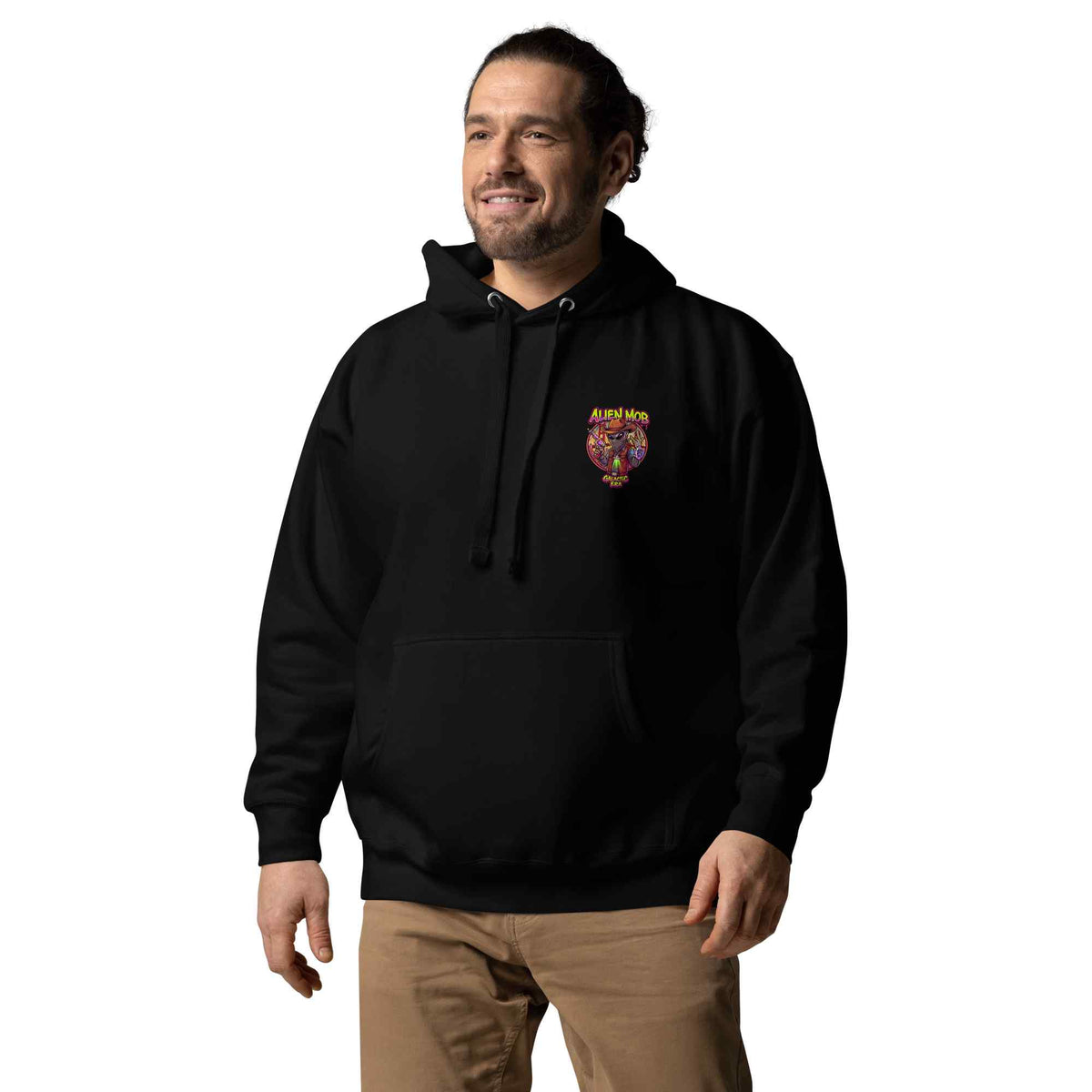 man wearing a black color hoodie with a logo on the left side chest of a design alien mob cowboy outlaw paired with khaki jeans on a white background front view