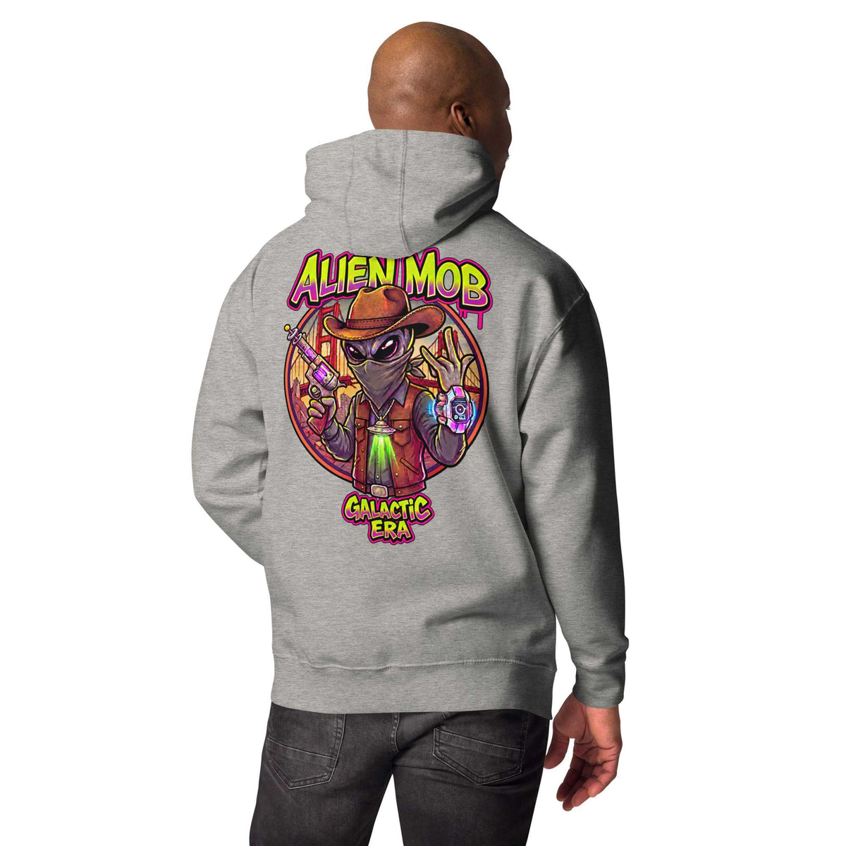 man wearing a Carbon stone grey hoodie with custom design alien mob cowboy outlaw print on the back of pullover hoodie paired with black jeans on a white background back view