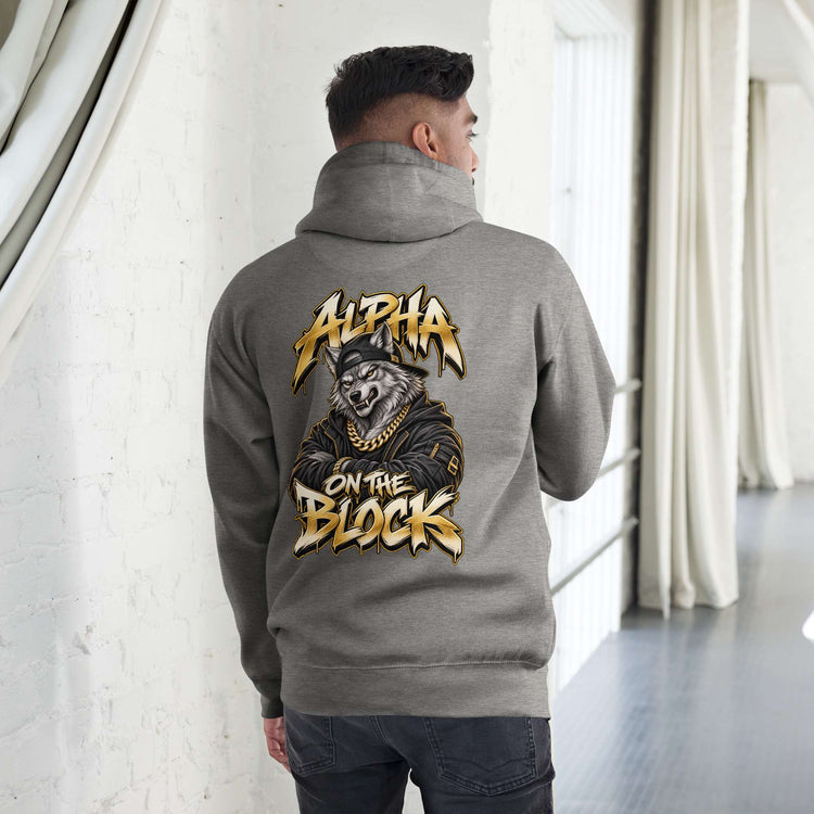 A man viewed from behind wearing a heather gray hoodie with a large graphic print on the back. The graphic features a wolf wearing a gold chain and the text 'ALPHA ON THE BLOCK' in a gold and black graffiti-style font.