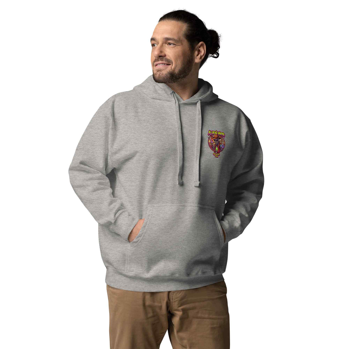 Proman wearing a Carbon stone gray color hoodie with a logo on the left side chest of a design alien mob cowboy outlaw paired with khaki jeans on a white background front viewduct mockup