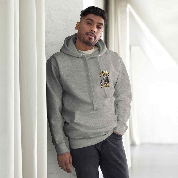 Man wearing a gray hoodie with a logo and text, standing against a white wall.