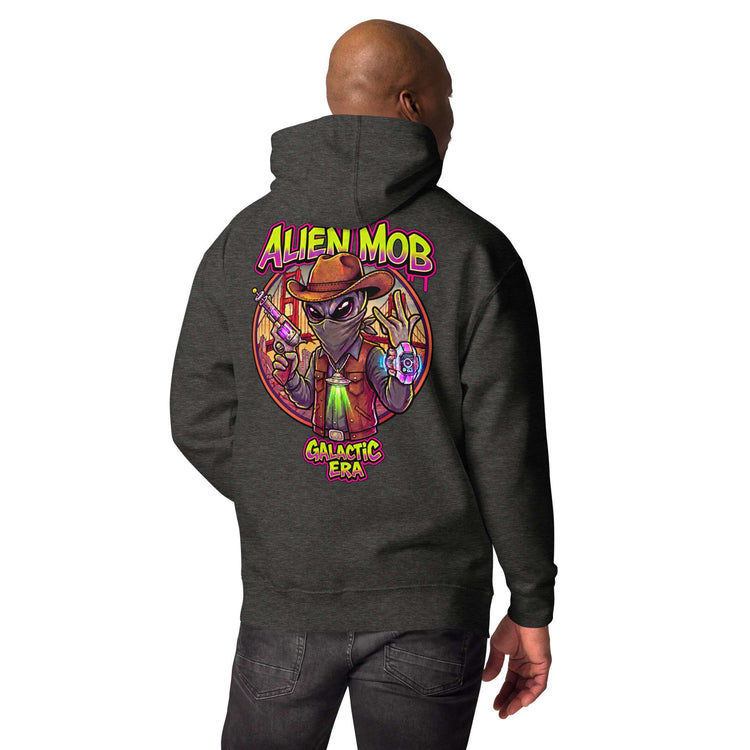 man wearing a charcoal hoodie with custom design alien mob cowboy outlaw print on the back of pullover hoodie paired with black jeans on a white background back view