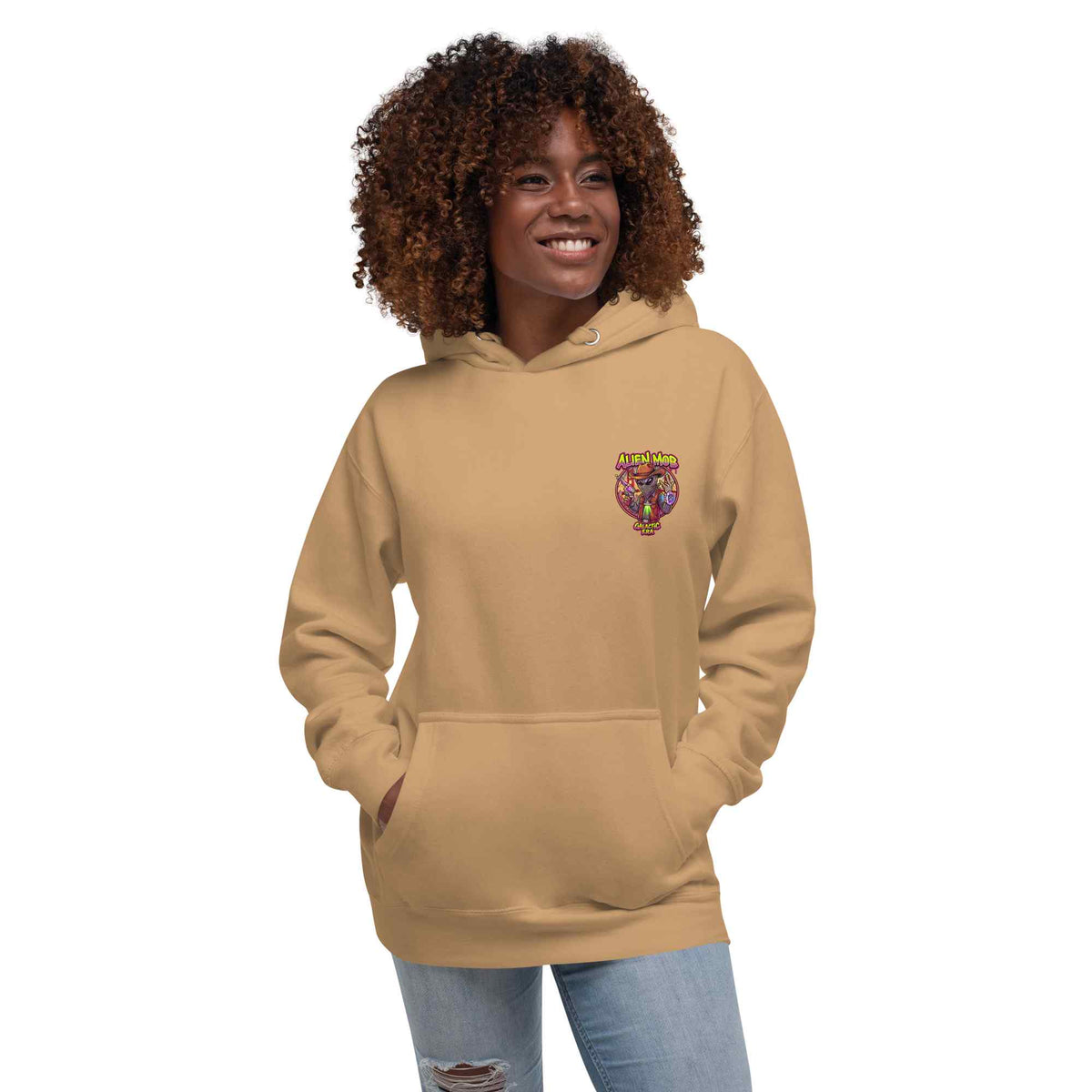 woman wearing a khaki hoodie with alien mob cowboy outlaw logo on the left side chest paired with blue jeans on a white background front view