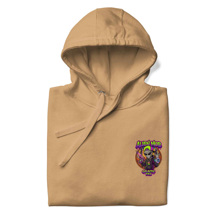 A khaki color  folded pullover hoodie with a colorful 'Alien mob logo graphic printed on the left chest, displayed on a clean white background.