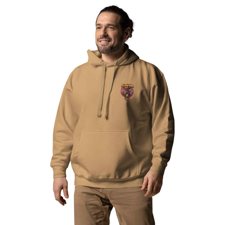 man wearing a khaki color hoodie with a logo on the left side chest of a design alien mob cowboy outlaw paired with khaki jeans on a white background front view