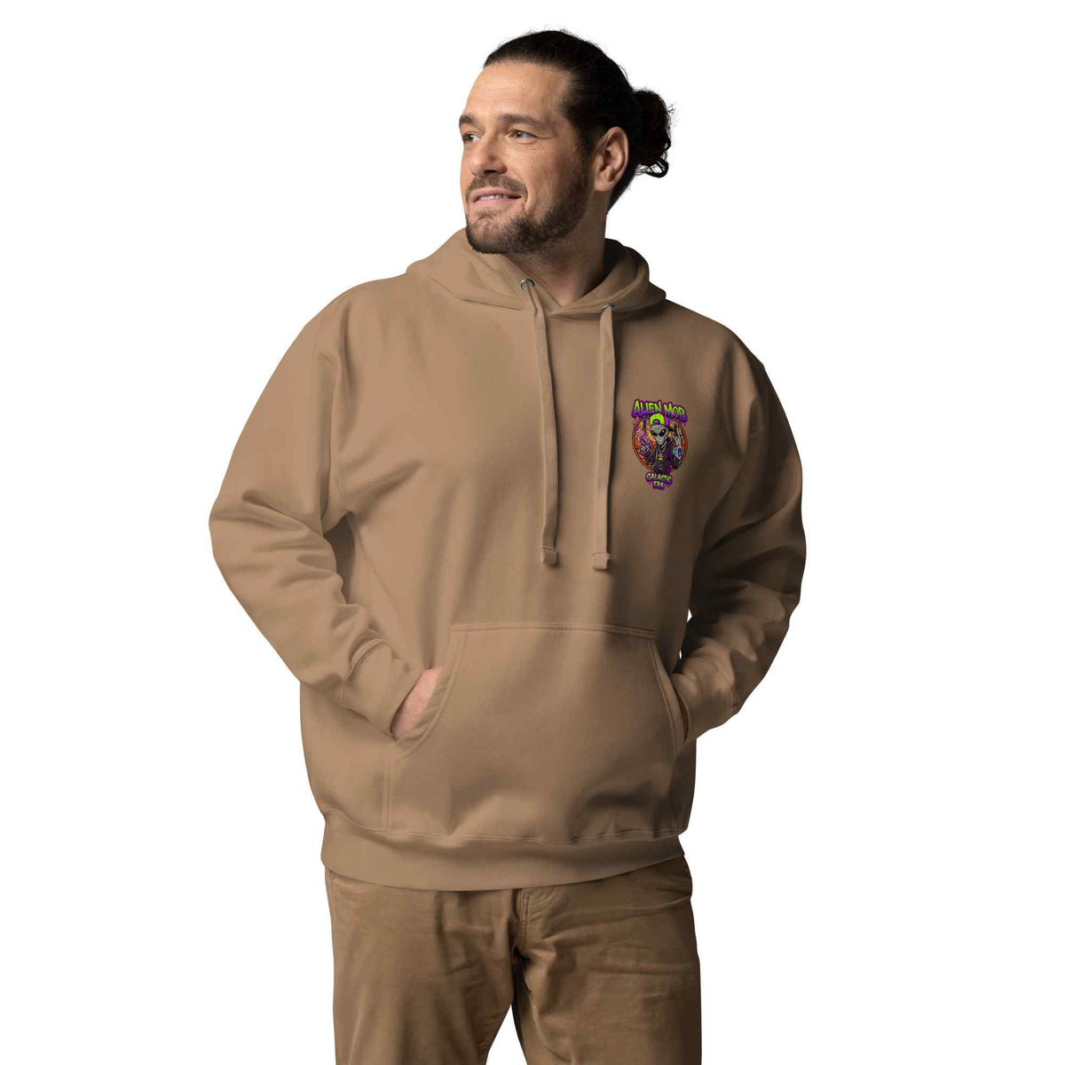 Man wearing a latte color hoodie with an alien mob logo on  left side chest  on a white background