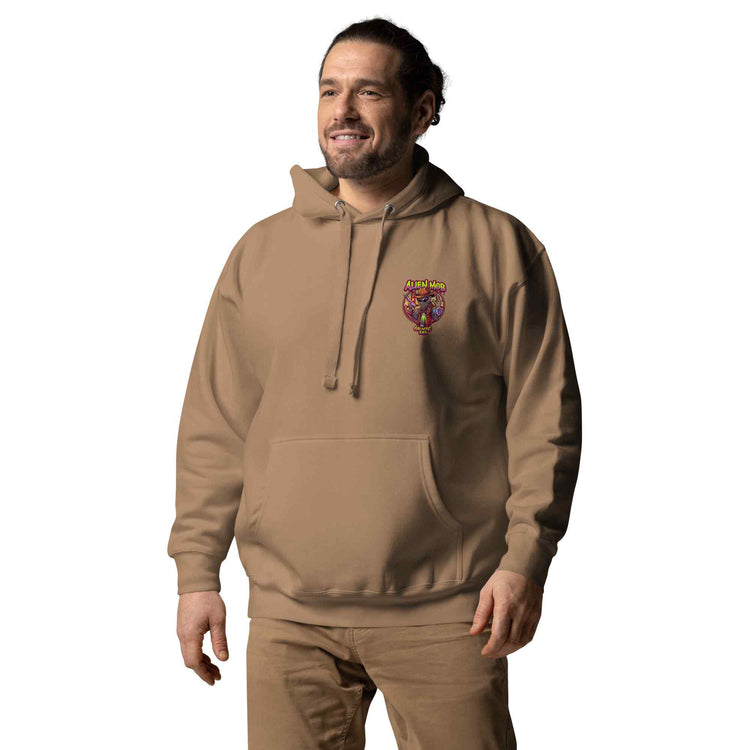man wearing a latte color hoodie with a logo on the left side chest of a design alien mob cowboy outlaw paired with khaki jeans on a white background front view