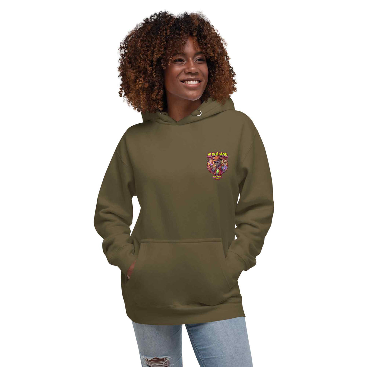 woman wearing a military hoodie with alien mob cowboy outlaw logo on the left side chest paired with blue jeans on a white background front view