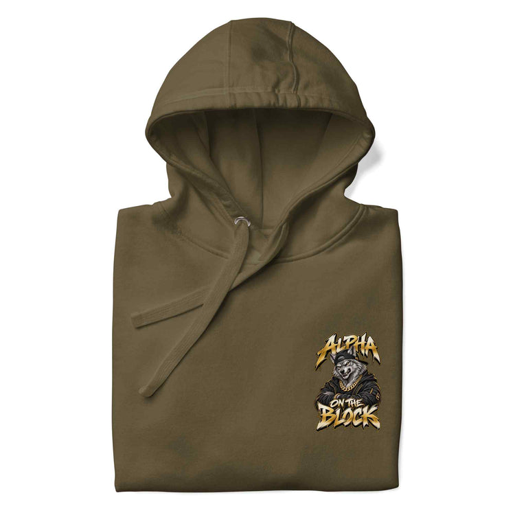 An olive green hooded sweatshirt, folded neatly, featuring a wolf graphic print on the left chest with the text 'ALPHA ON THE BLOCK' and a bear illustration, set against a plain white background.