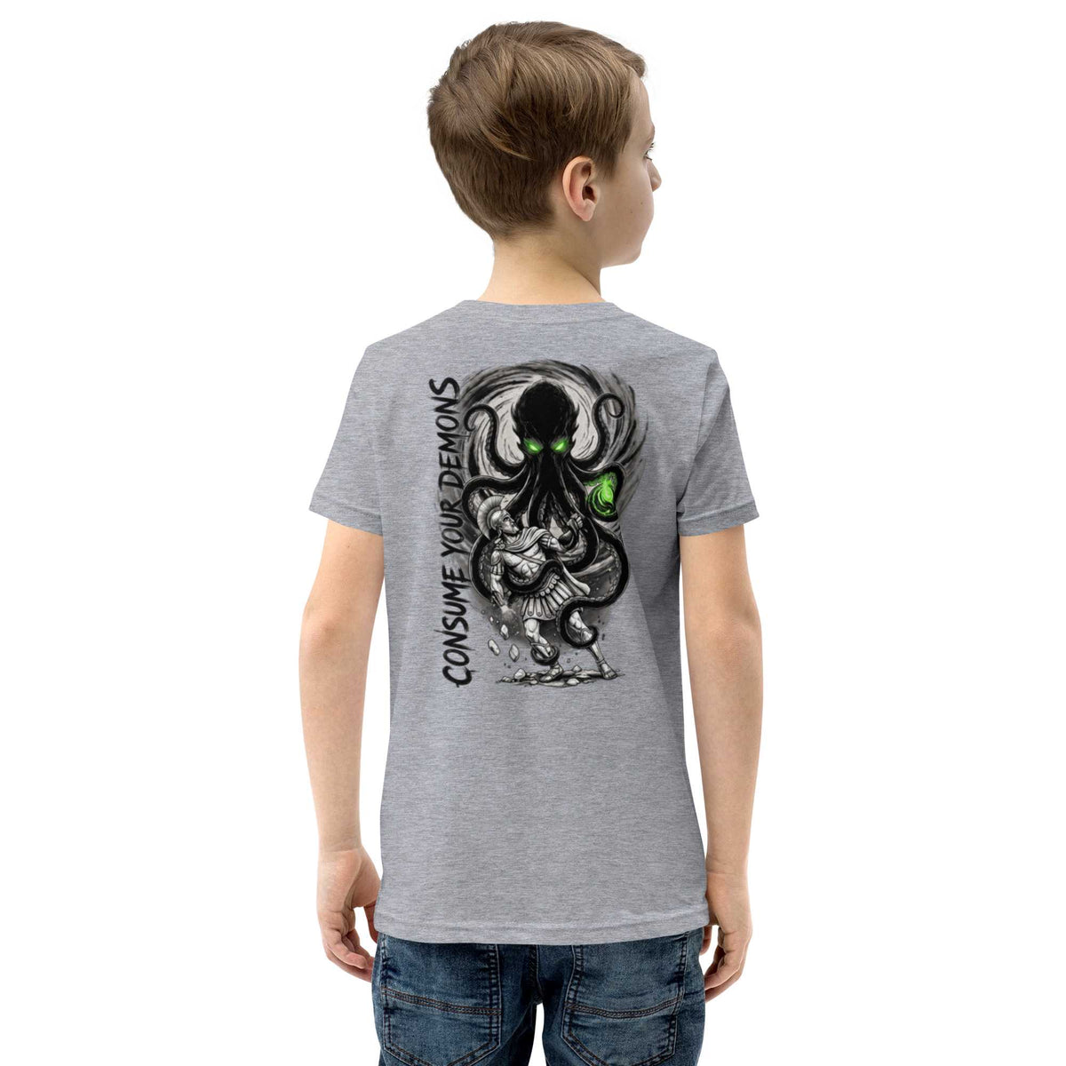 A child wearing a heather gray t-shirt, viewed from the back. The shirt features a large graphic print of a black octopus-like creature with glowing green eyes and the text 'CONSUME YOUR DEMONS' in black.