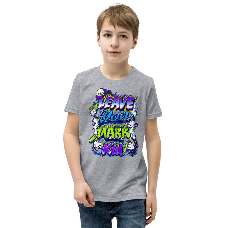 A young boy wearing a heather gray t-shirt with a colorful graphic that reads 'LEAVE YOUR MARK Kid' in purple, blue, and green, paired with blue jeans, against a plain white background.