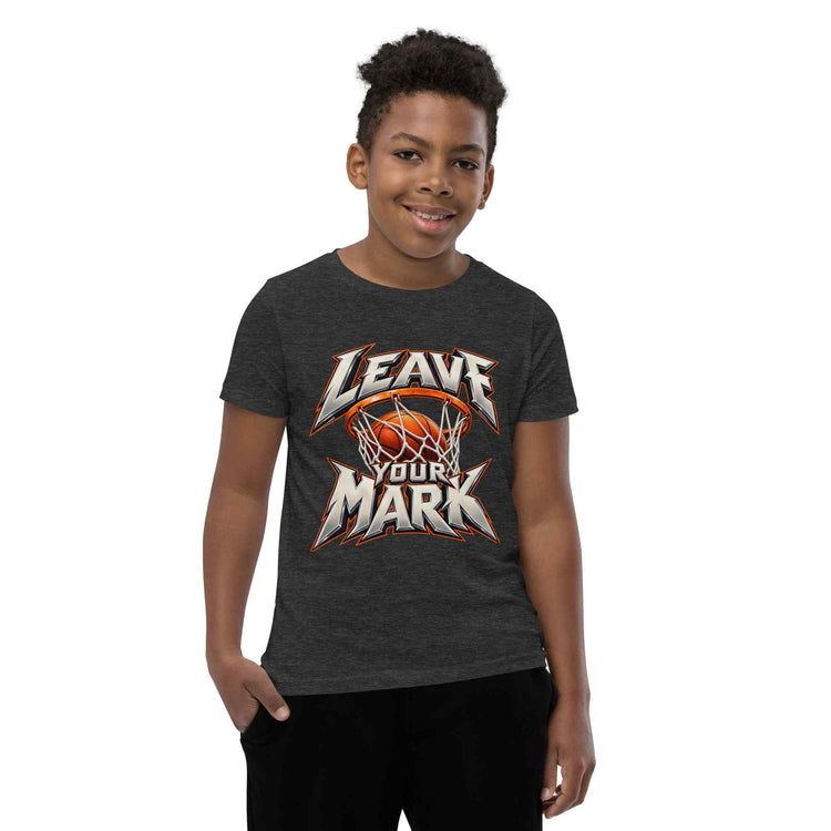 A young boy wearing a dark green heather t-shirt with a leave your mark graphic on the front, paired with black pants, set against a plain white background.