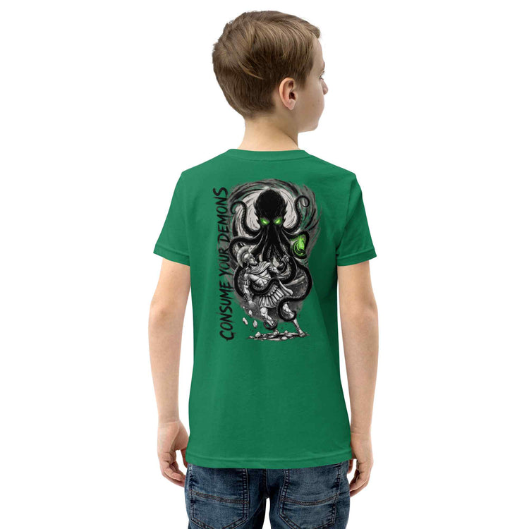 A child model shown from the back wearing a green t-shirt with a large black and gray octopus graphic and the text 'CONSUME YOUR DEMONS' printed on the back.