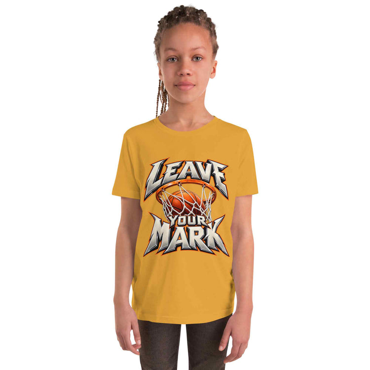A young girl with braided hair wearing a yellow t-shirt with a 'LEAVE YOUR MARK' basketball graphic, standing against a plain white background.