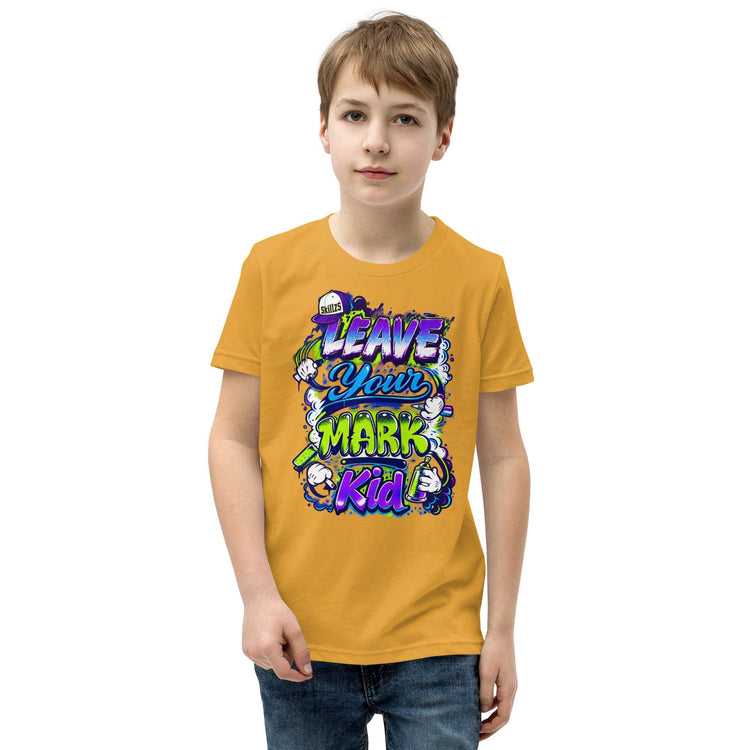 A young boy wearing a mustard yellow graphic t-shirt with a colorful 'Leave Your Mark Kid' design, paired with blue jeans, against a plain white background.