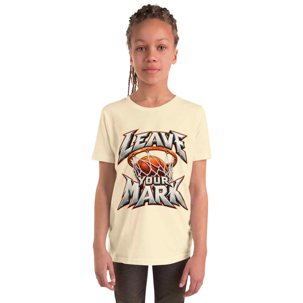 A young girl with braided hair wearing a cream-colored t-shirt with a basketball graphic that reads 'LEAVE YOUR MARK'.