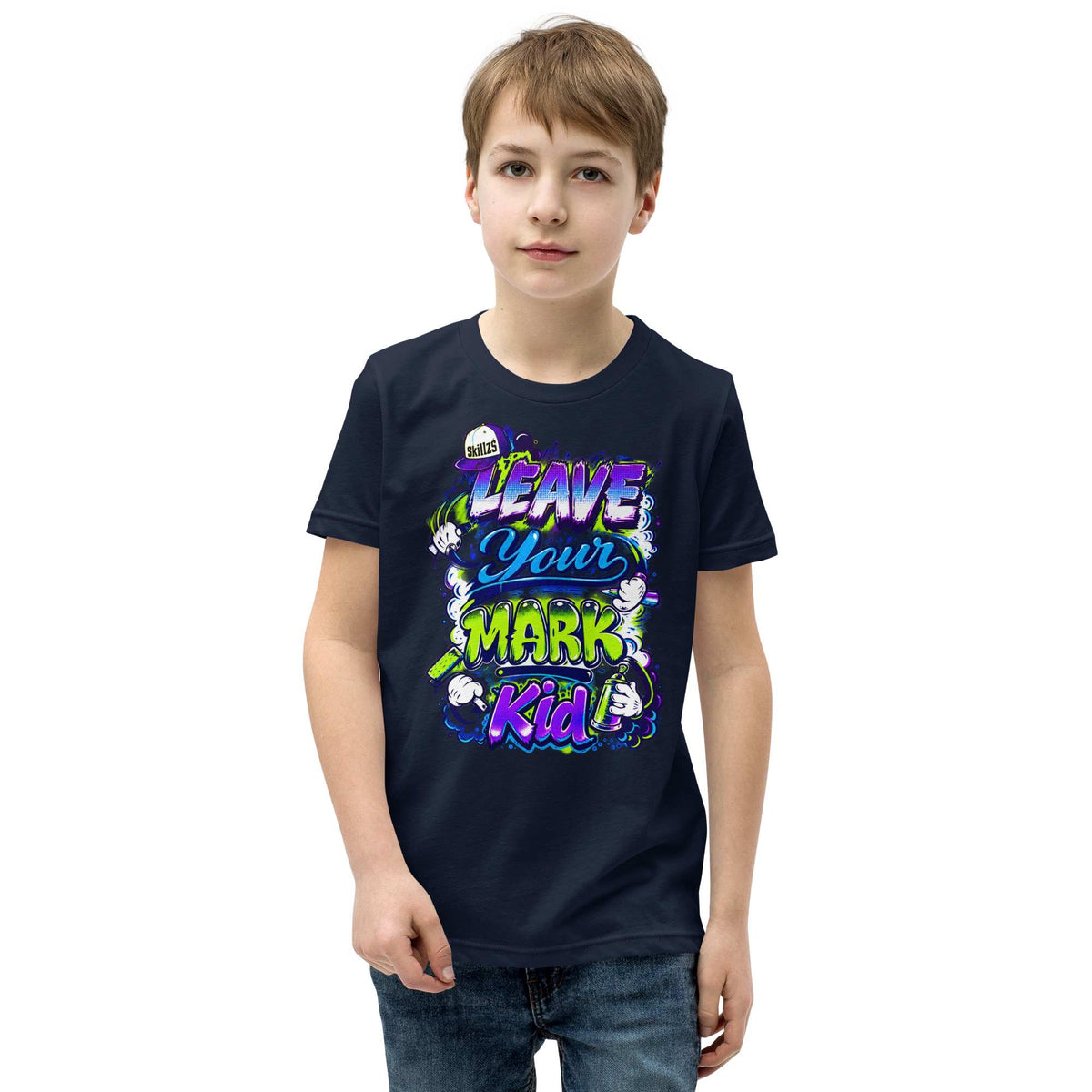 A young boy wearing a black graphic t-shirt with a colorful 'Leave Your Mark Kid' design, paired with blue jeans, set against a plain white background.