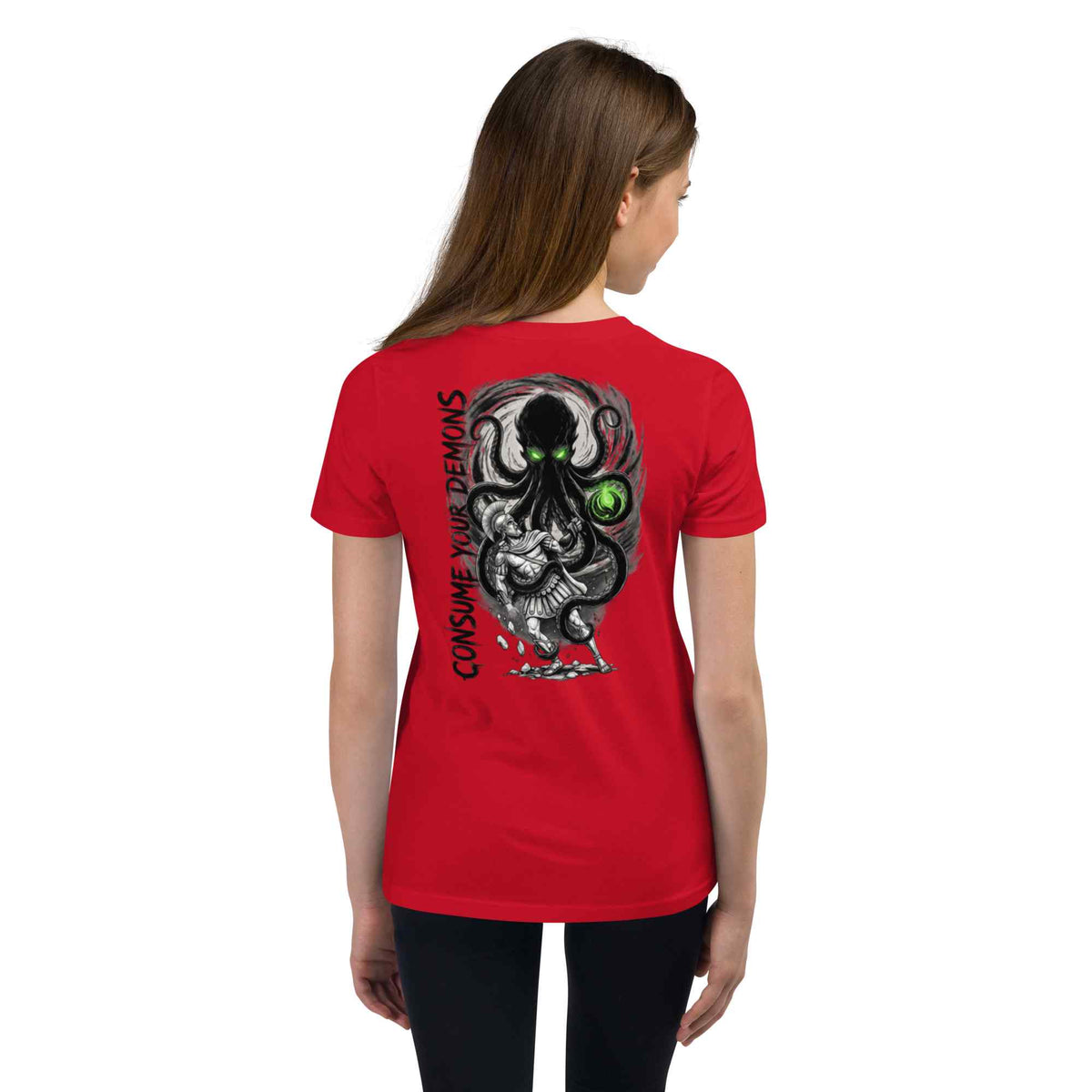 A woman viewed from the back wearing a bright red short-sleeve T-shirt with a large black, gray, and green graphic print on the back, plus vertical text reading 'CONSUME YOUR DEMONS.'.