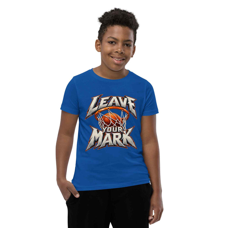 A young boy wearing a royal blue t-shirt with a 'LEAVE YOUR MARK' basketball graphic, standing against a plain white background.