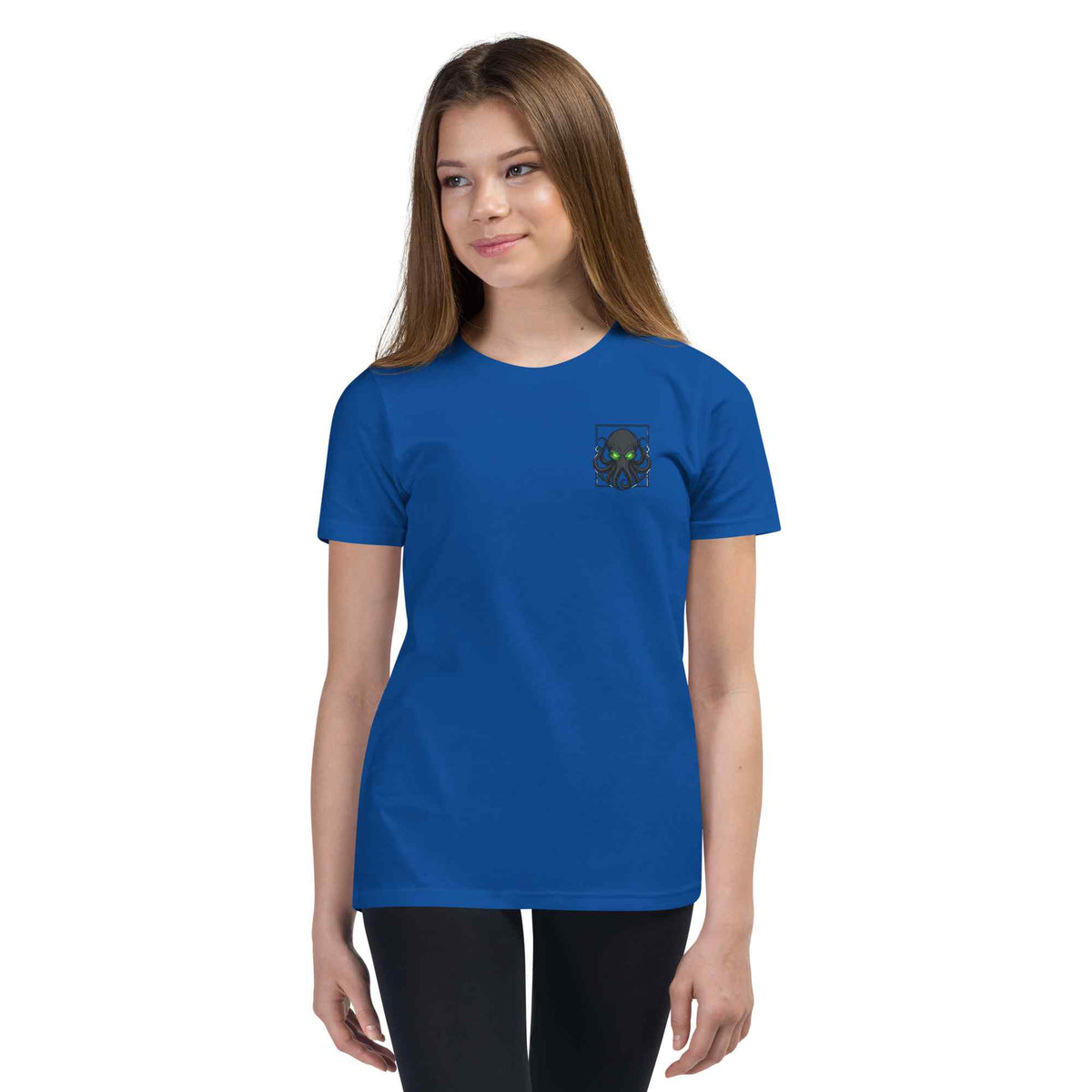 A young woman modeling a royal blue short-sleeve crewneck t-shirt with a small dark octopus graphic on the left chest, set against a plain white background.