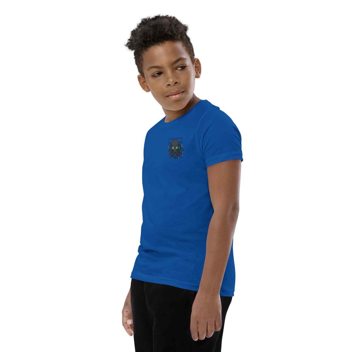 Child wearing a blue t-shirt with 'a kraken printed on it against a white background